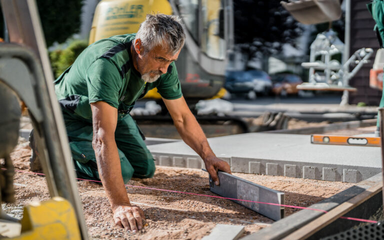 Unternehmensfotos Pöhler Gartenbau beim verlegen von Pflasterplatten